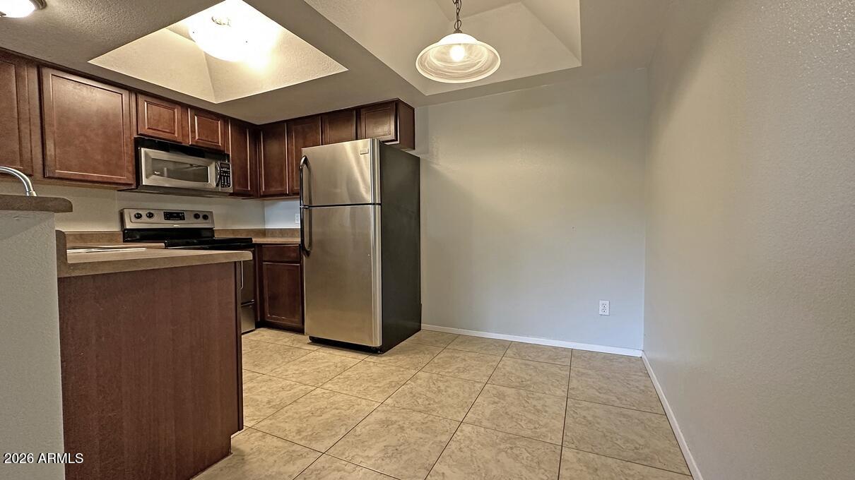 1720 East Thunderbird Road, Unit 2095 Phoenix, AZ 85022 - Photo 11 of 22 a kitchen with stainless steel appliances granite countertop a refrigerator stove top oven a sink and dishwasher