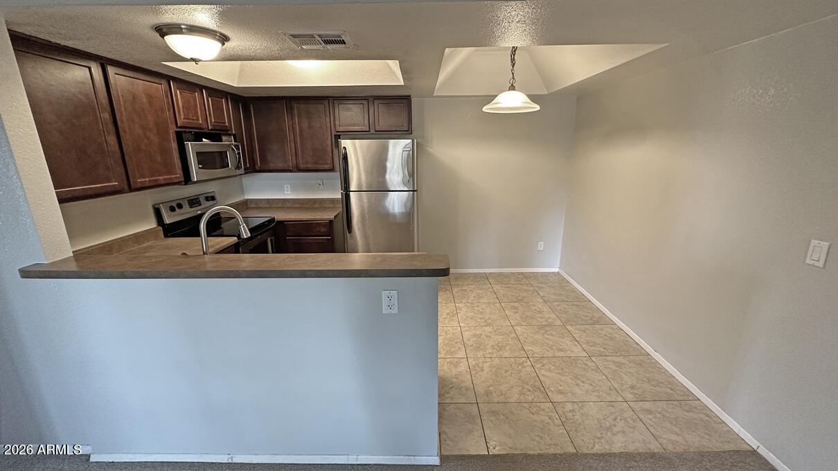 1720 East Thunderbird Road, Unit 2095 Phoenix, AZ 85022 - Photo 10 of 22 a kitchen with stainless steel appliances granite countertop a refrigerator and a sink