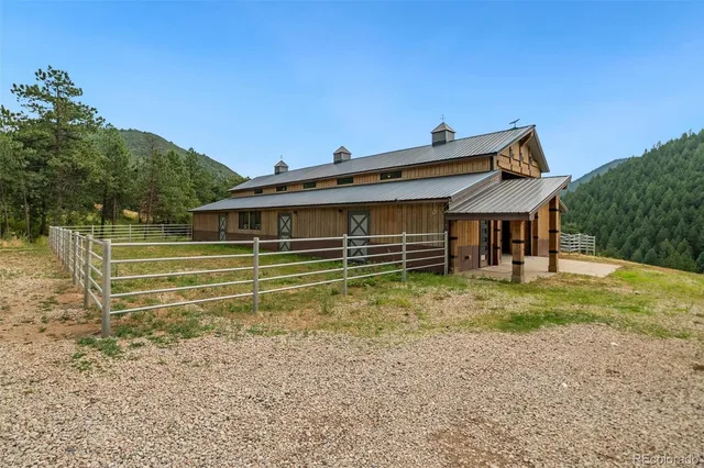 a view of a house with a yard and wooden fence