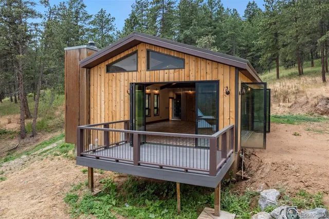 a view of a wooden house with a small deck and backyard