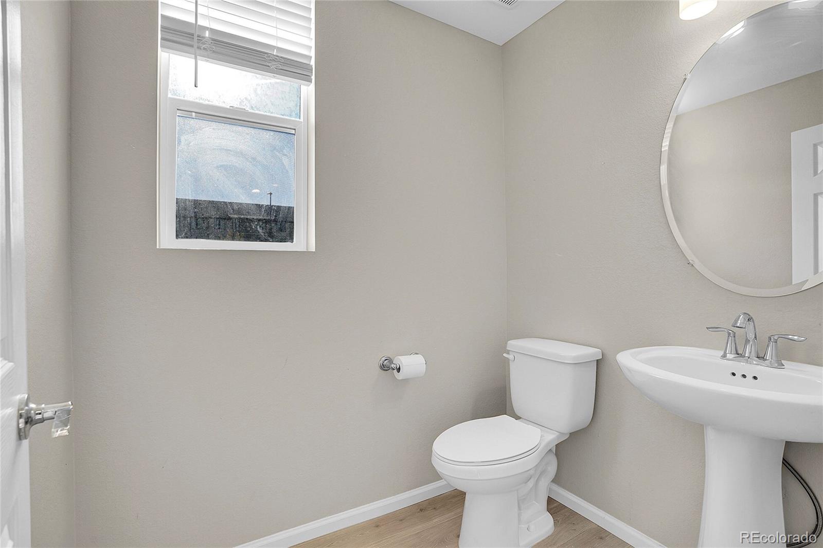 6419 North Dunkirk Street Denver, CO 80249 - Photo 15 of 31 a white toilet sitting next to a bathroom sink
