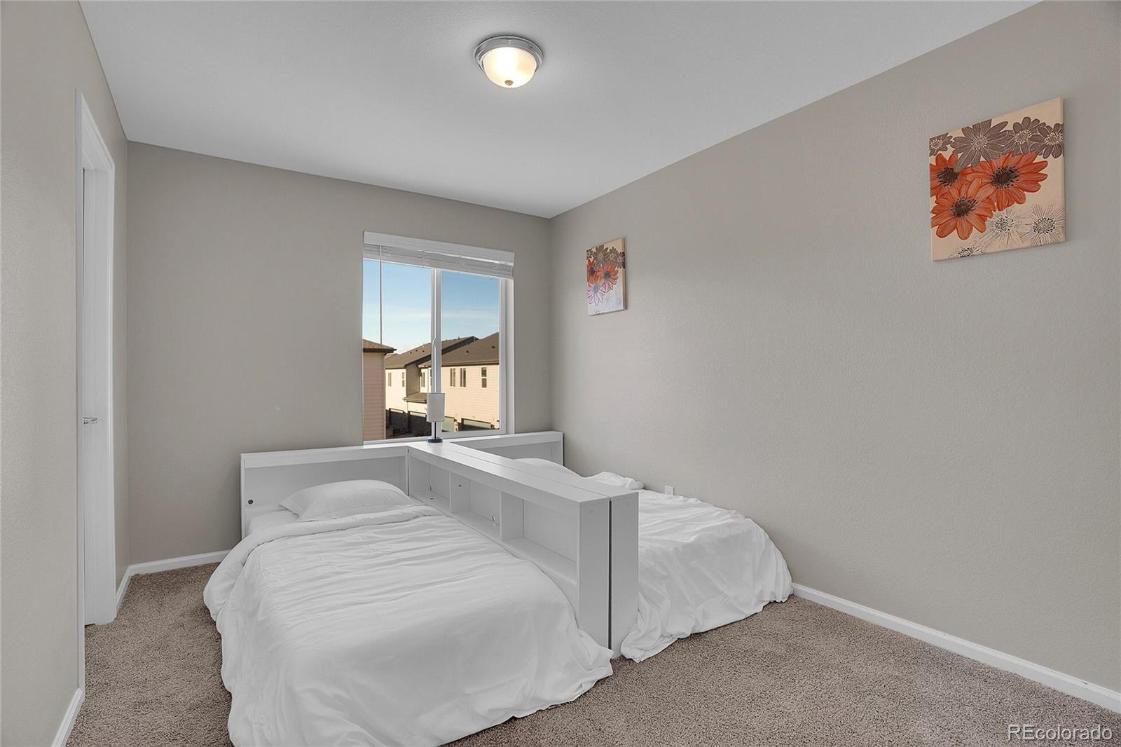 6419 North Dunkirk Street Denver, CO 80249 - Photo 16 of 31 a bedroom with a bed and a painting on the wall