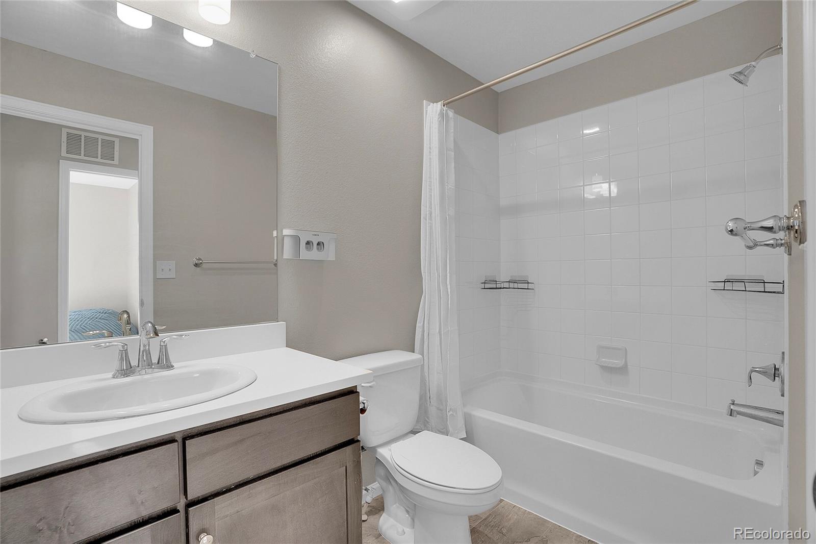 6419 North Dunkirk Street Denver, CO 80249 - Photo 17 of 31 a bathroom with a sink toilet vanity and shower