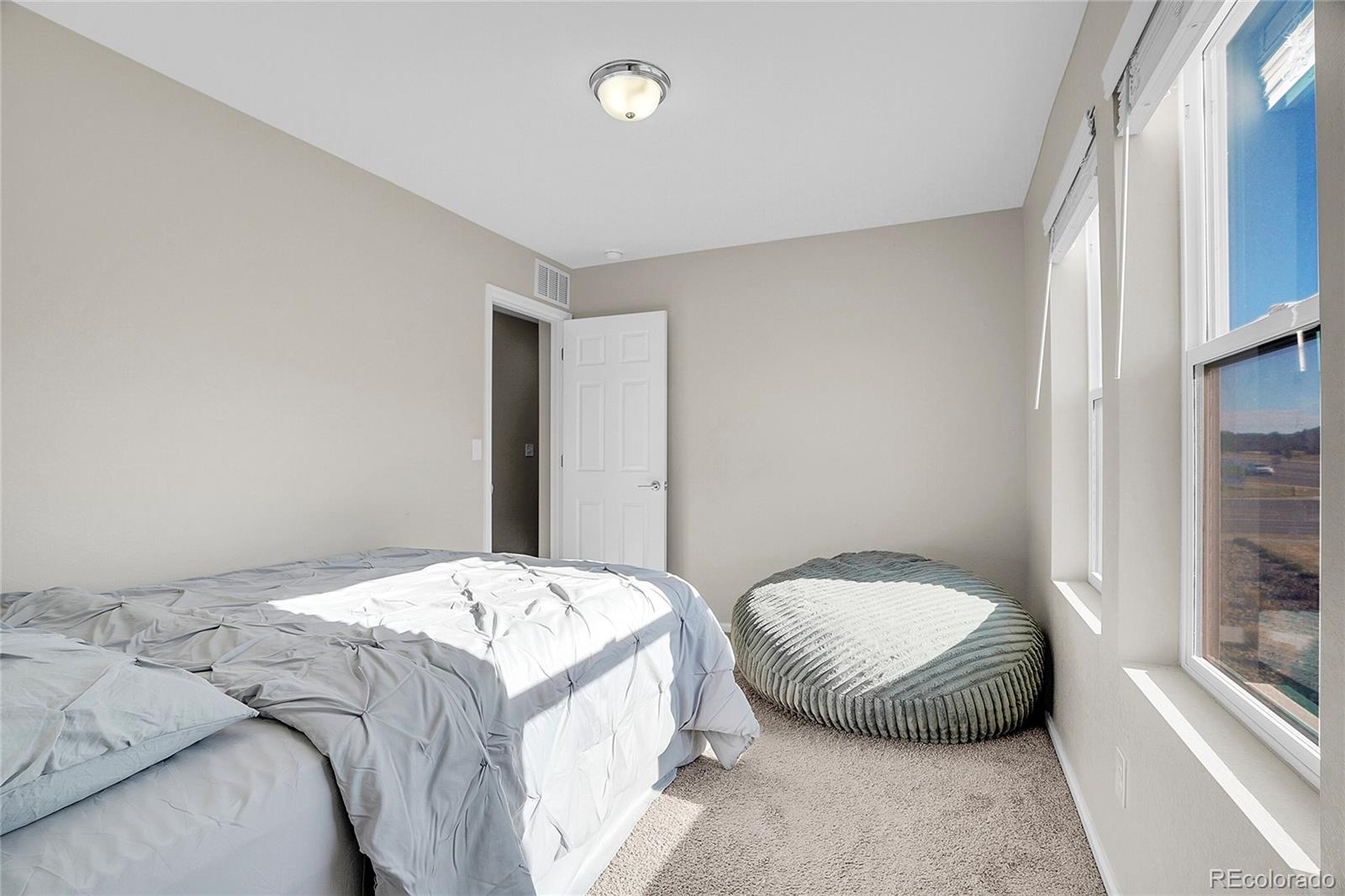 6419 North Dunkirk Street Denver, CO 80249 - Photo 19 of 31 a bedroom with a bed and a mirror