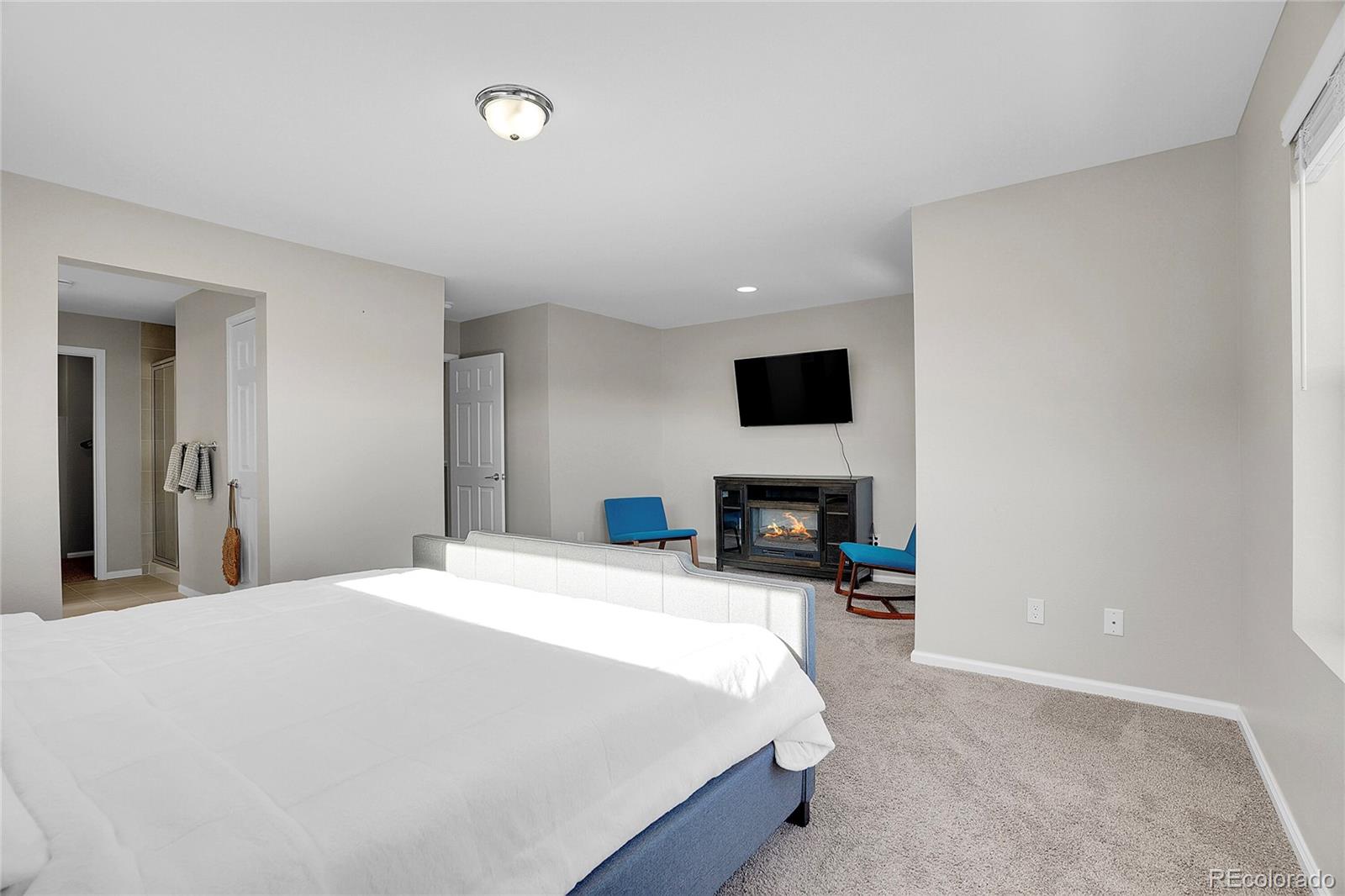 6419 North Dunkirk Street Denver, CO 80249 - Photo 23 of 31 a large white bed in a bedroom and a fireplace