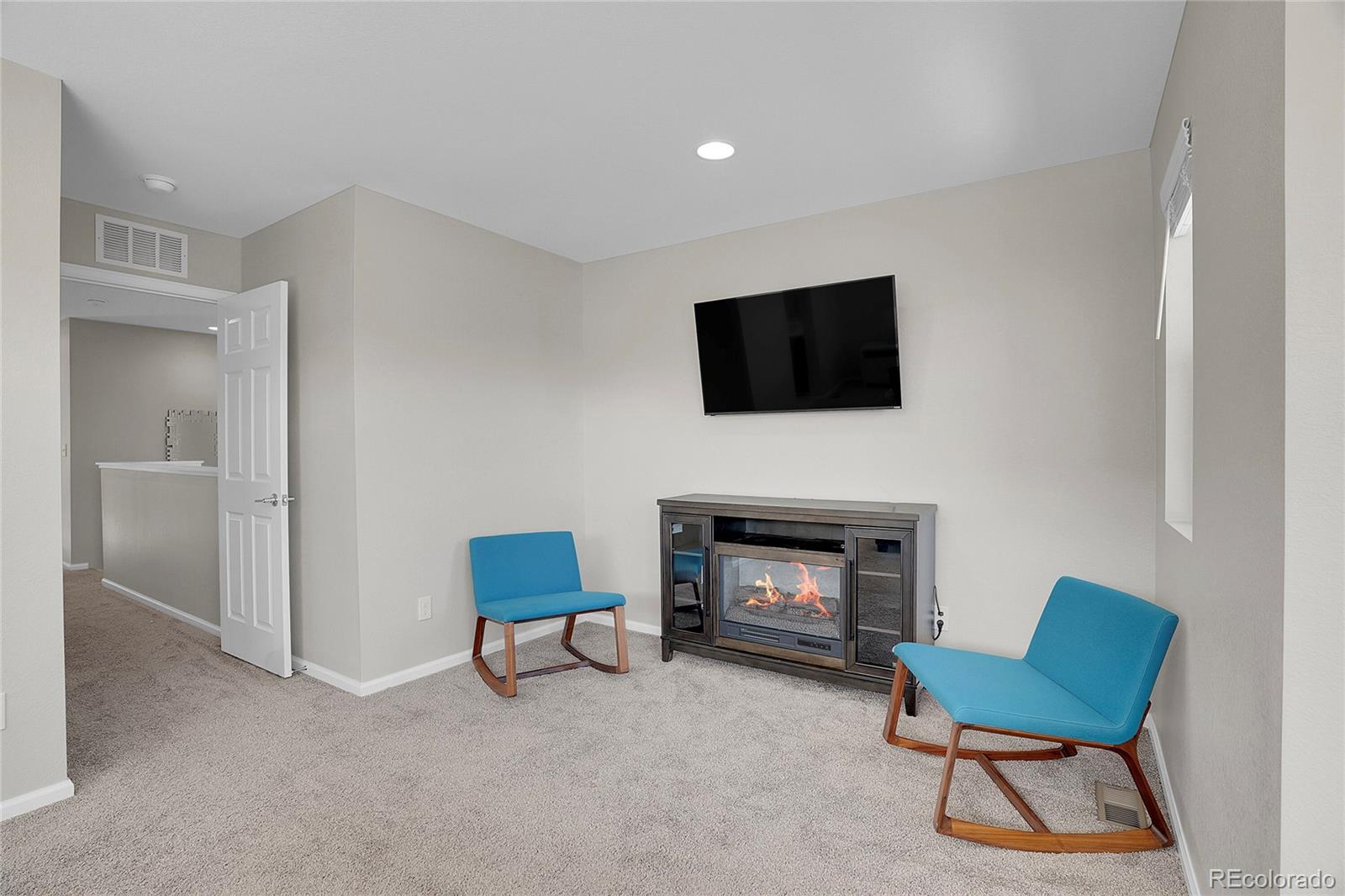 6419 North Dunkirk Street Denver, CO 80249 - Photo 25 of 31 a living room with furniture a fireplace and a flat screen tv