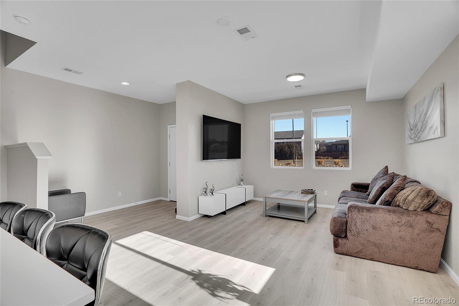 6419 North Dunkirk Street Denver, CO 80249 - Photo 6 of 31 a living room with furniture and a flat screen tv