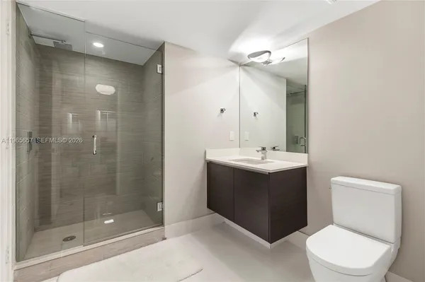 a bathroom with a sink vanity mirror and toilet