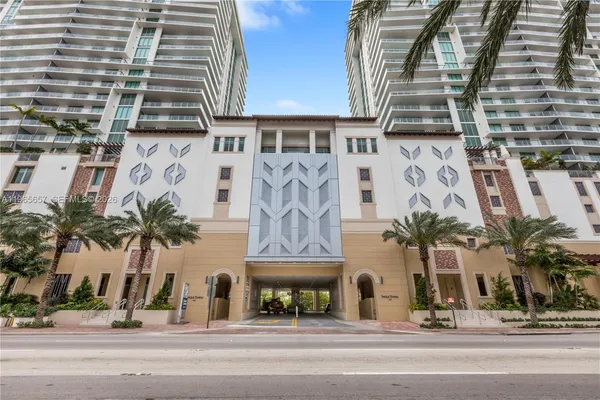 front view of a building with palm trees