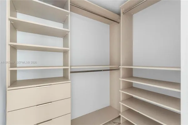a view of walk in closet with empty racks
