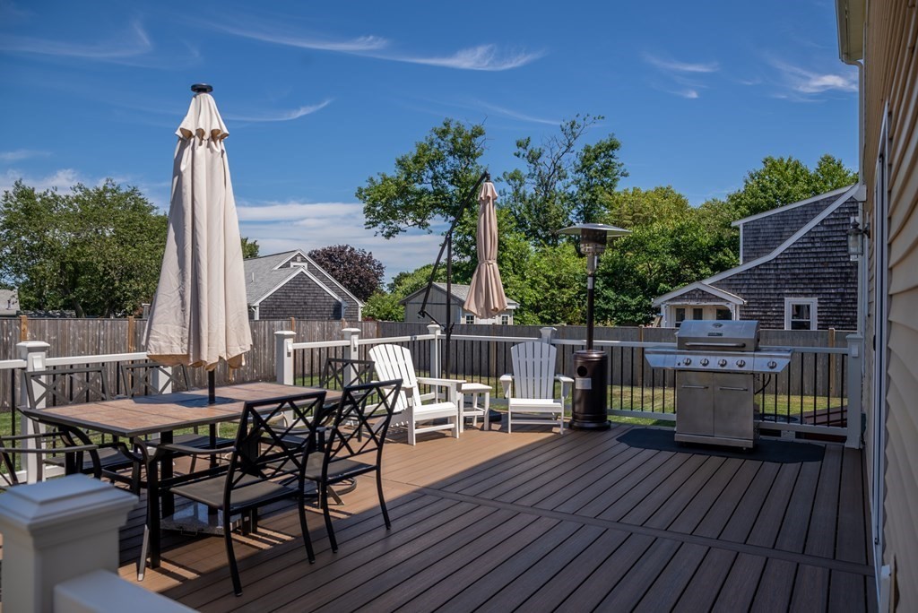 106 Colonial Road Marshfield, MA 02050 - Photo 26 of 42 a view of a roof deck with table and chairs couches with wooden floor and fence