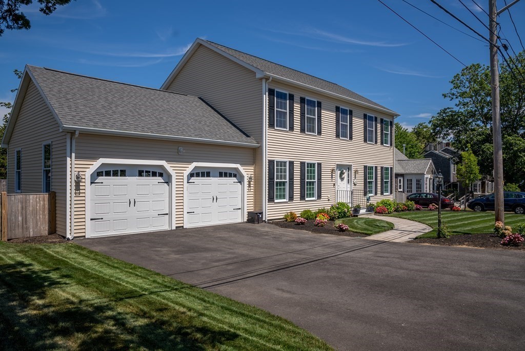 106 Colonial Road Marshfield, MA 02050 - Photo 34 of 42 a front view of a house with a yard and garage
