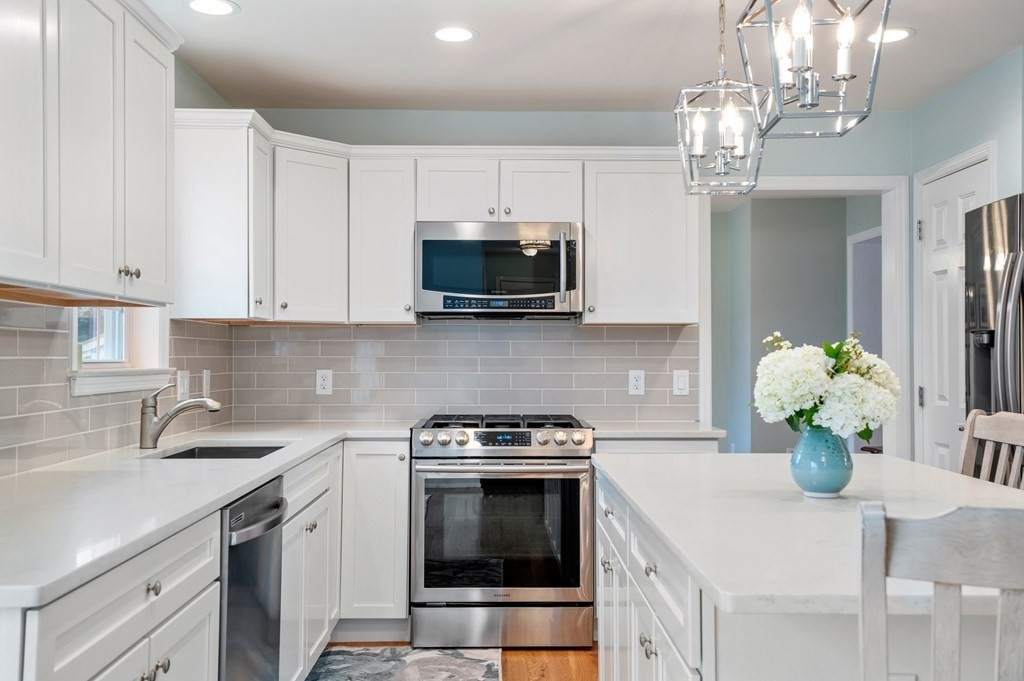 106 Colonial Road Marshfield, MA 02050 - Photo 4 of 42 a kitchen with stainless steel appliances granite countertop a sink a stove and cabinets