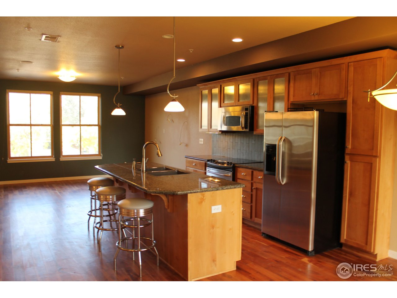 325 Cherry Street, Unit 210 Fort Collins, CO 80521 - Photo 4 of 13 a kitchen with stainless steel appliances granite countertop a refrigerator a sink a stove and wooden floor