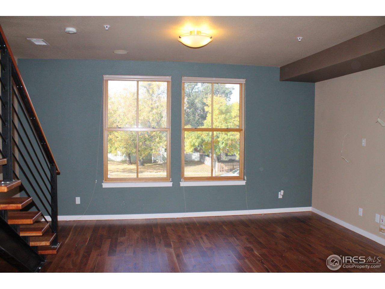 325 Cherry Street, Unit 210 Fort Collins, CO 80521 - Photo 8 of 13 an empty room with wooden floor and windows