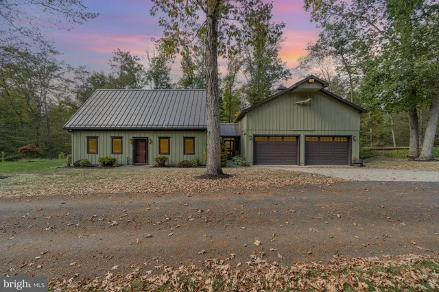 a front view of a house with a yard and trees