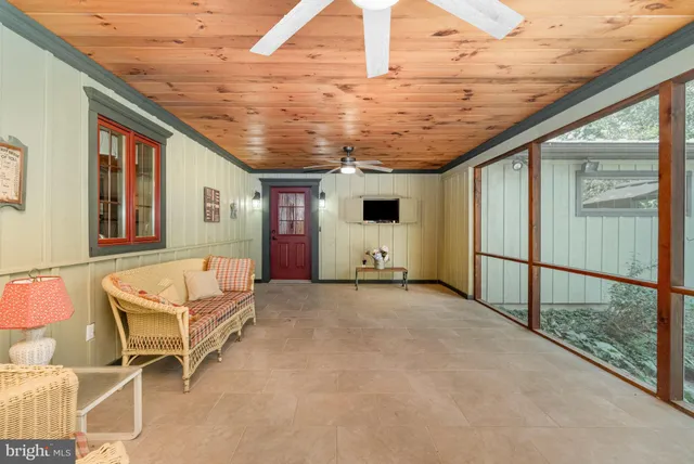 a spacious bedroom with a bed a chair and the dresser