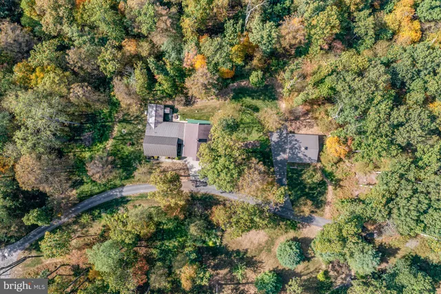 a aerial view of a house with a yard and trees