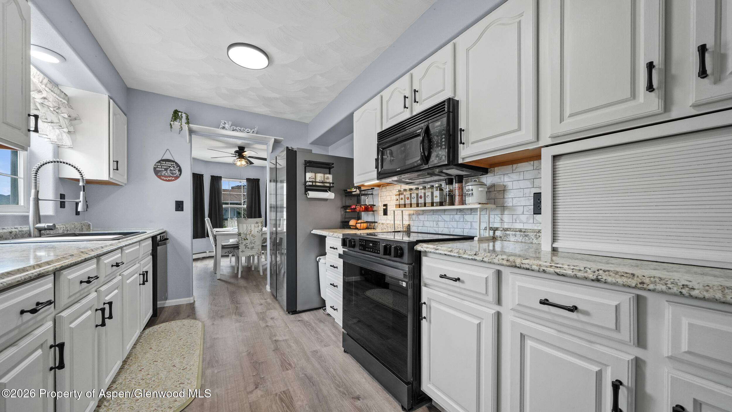 2750 East Avenue Rifle, CO 81650 - Photo 11 of 35 a kitchen with white cabinets and stainless steel appliances
