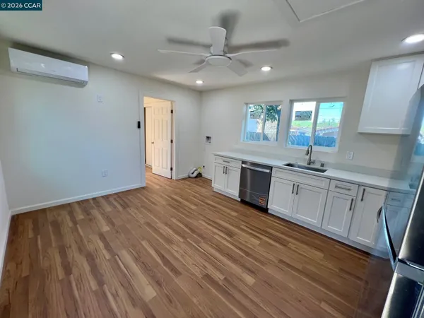 a view of a kitchen counter space with stainless steel appliances wooden floor and staircase