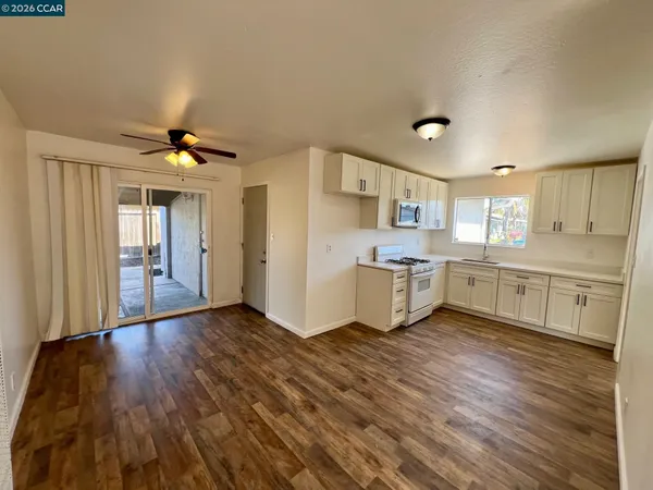 a view of a kitchen with wooden floor and electronic appliances