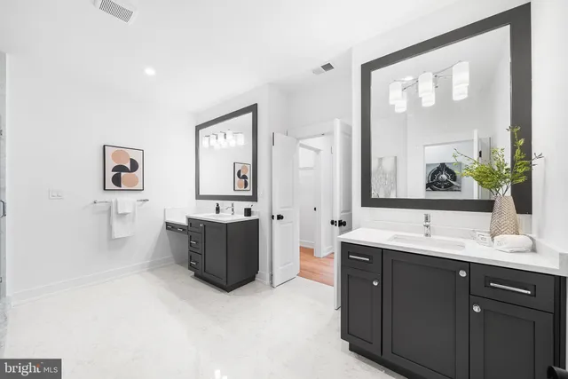 a bathroom with a granite countertop double vanity sink a mirror and a bathtub