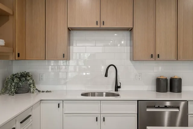 a kitchen with stainless steel appliances granite countertop a sink a stove and cabinets