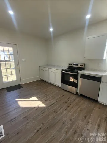 a kitchen with wooden floors and stainless steel appliances