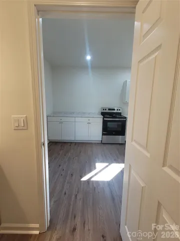 a kitchen with a wooden floor and white cabinets