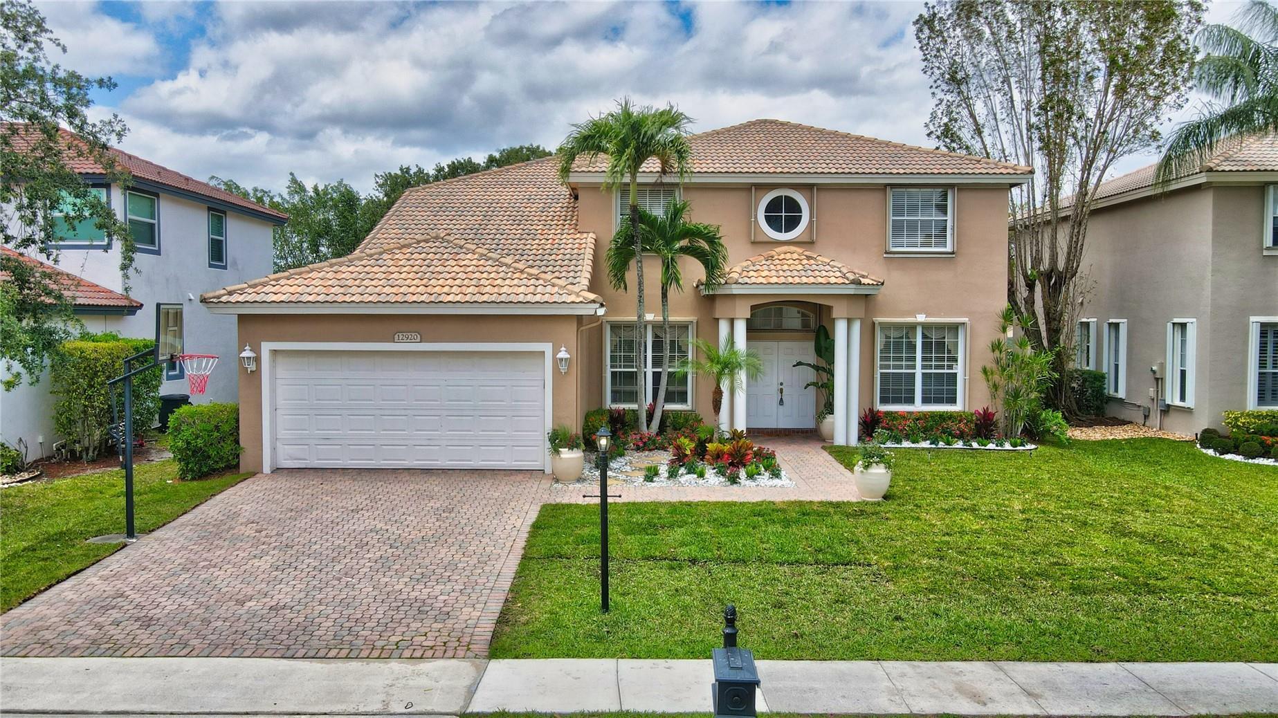 12920 Hyland Circle Boca Raton, FL 33428 - Photo 1 of 31 a front view of a house with a yard and garage