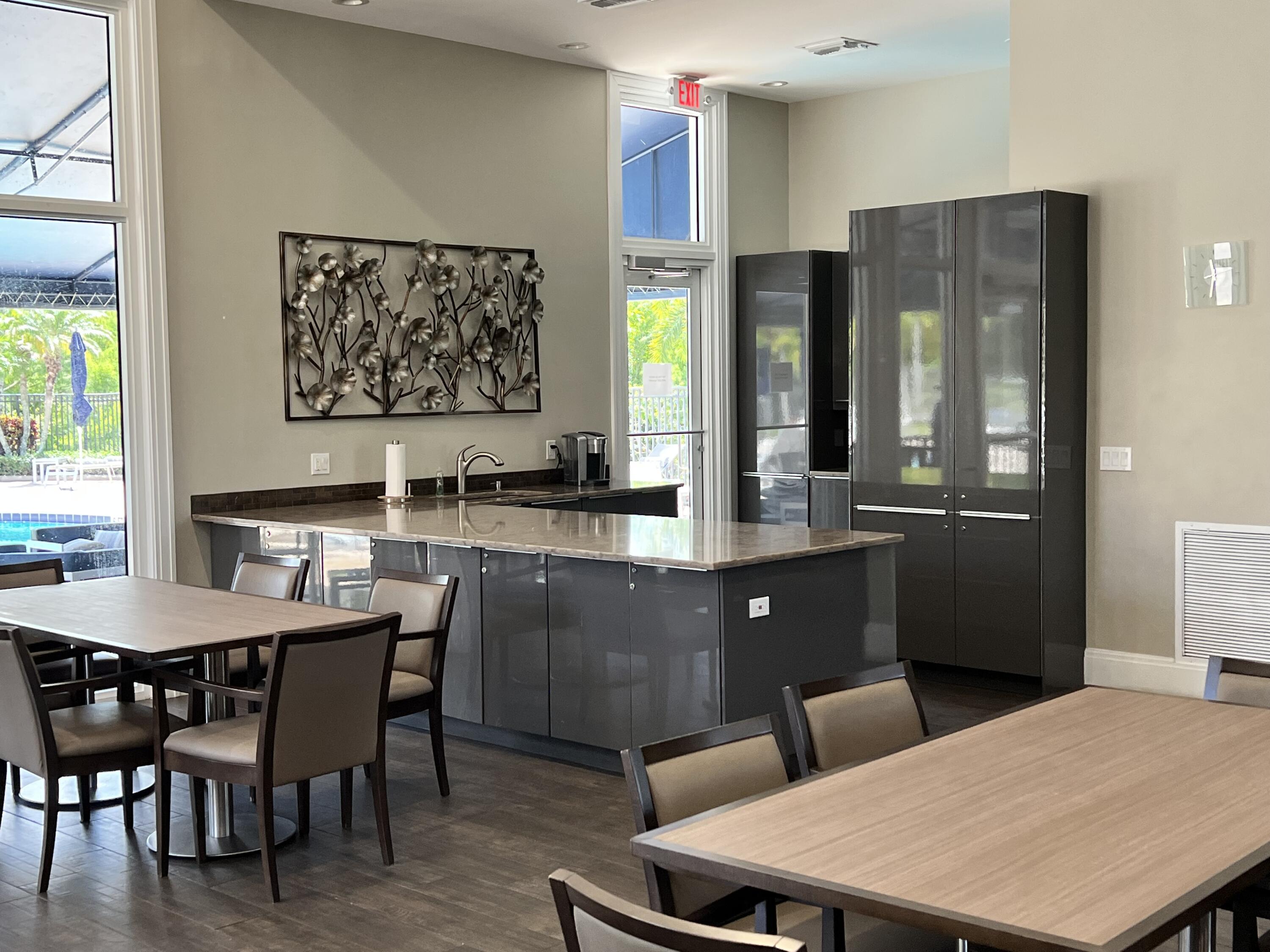 12920 Hyland Circle Boca Raton, FL 33428 - Photo 27 of 31 a kitchen with a table chairs and a refrigerator