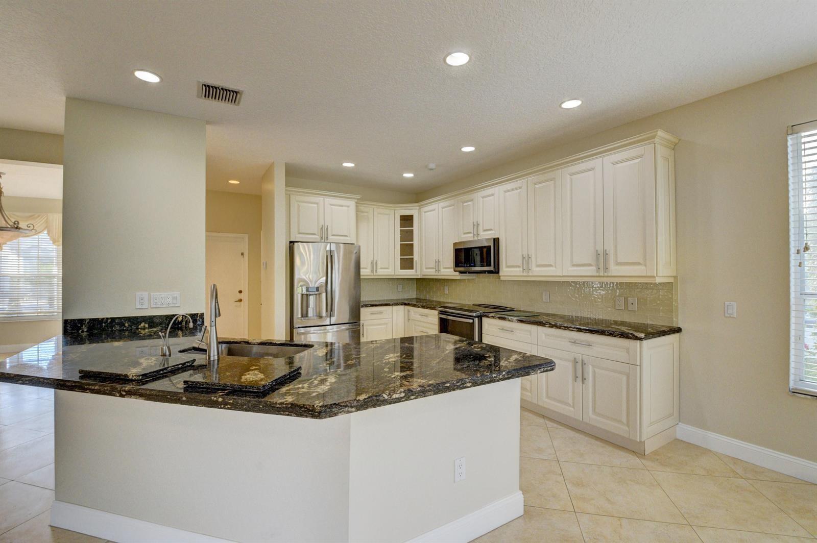 12920 Hyland Circle Boca Raton, FL 33428 - Photo 8 of 31 a kitchen with stainless steel appliances granite countertop a sink and cabinets