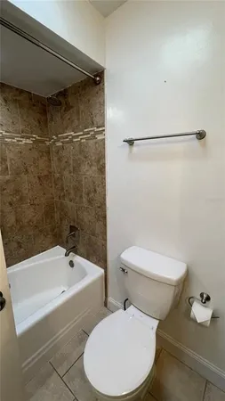 a white toilet sitting next to a bath tub