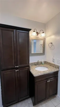 a bathroom with a granite countertop sink and a mirror