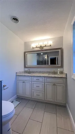 a bathroom with a granite countertop sink and mirror