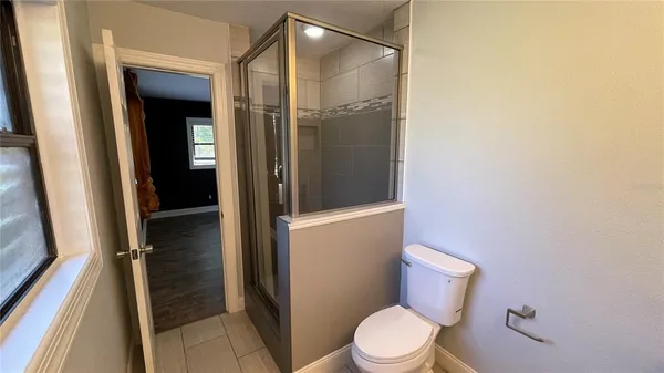 a white toilet sitting next to a shower