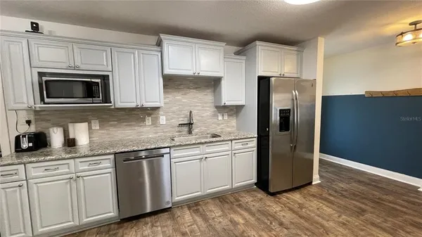 a kitchen with granite countertop cabinets stainless steel appliances and a counter space