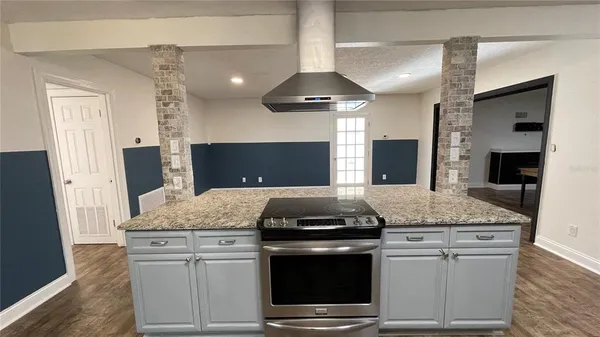 a kitchen with granite countertop cabinets stainless steel appliances and wooden floor
