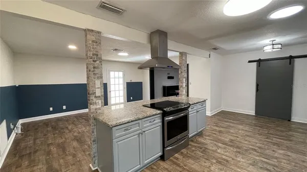 a kitchen with granite countertop a stove and a sink