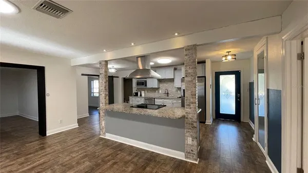 a view of a hallway with kitchen and stainless steel appliances