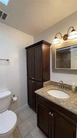 a bathroom with a granite countertop sink and a mirror