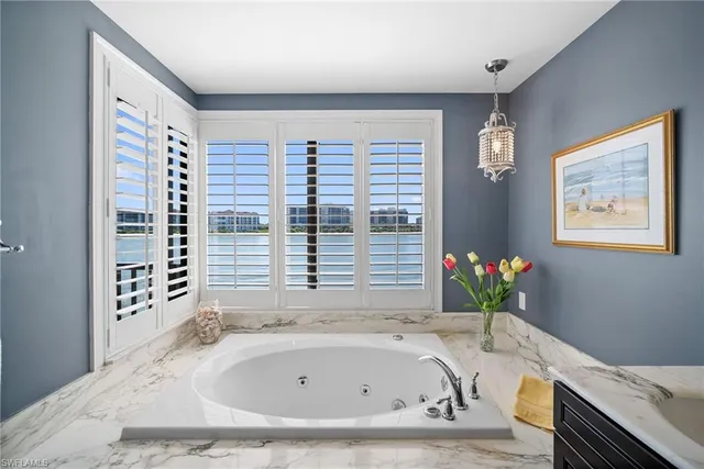 a bathroom with a granite countertop sink and a bathtub