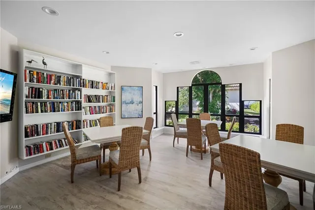 a dining room with furniture large window and wooden floor
