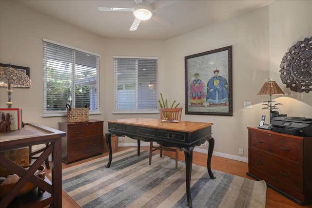 a view of a workspace with furniture and a window