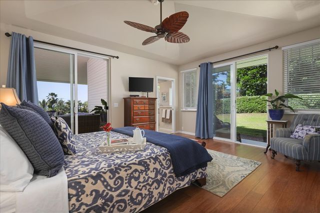 a bedroom with a bed a couch and a flat tv screen