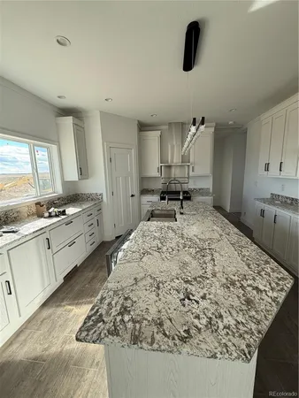 a kitchen with white cabinets and sink