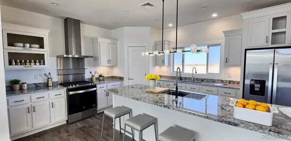 a kitchen with stainless steel appliances granite countertop a stove and a refrigerator