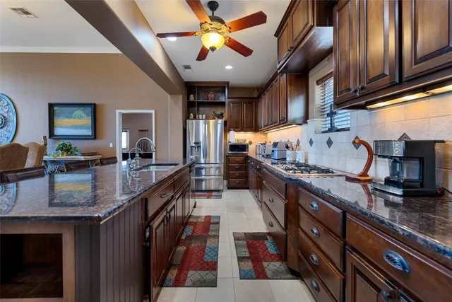 a kitchen with stainless steel appliances granite countertop a stove a sink dishwasher and cabinets with wooden floor