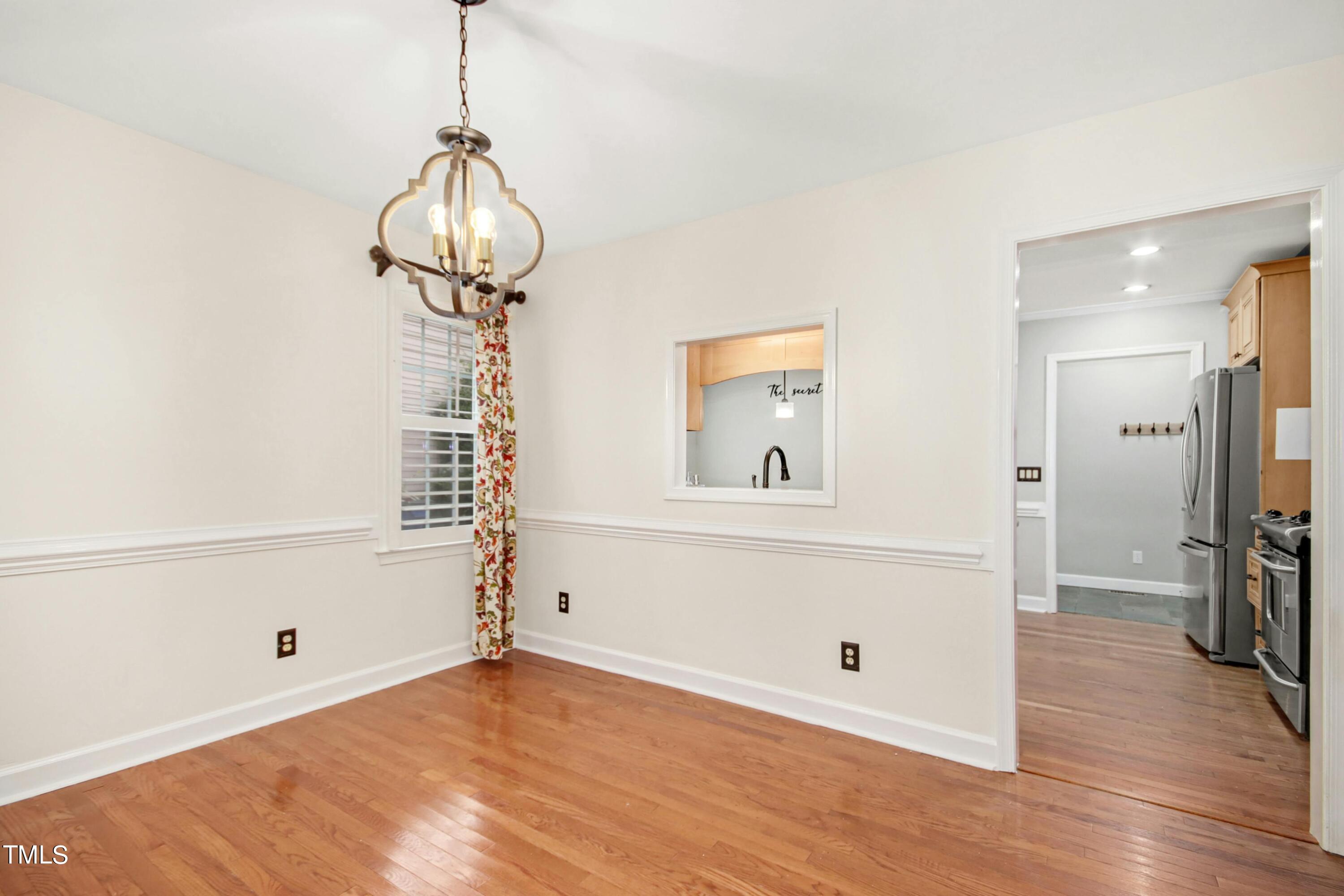 8605 Yucca Trail Raleigh, NC 27615 - Photo 11 of 42 a view of a livingroom with wooden floor and chandelier