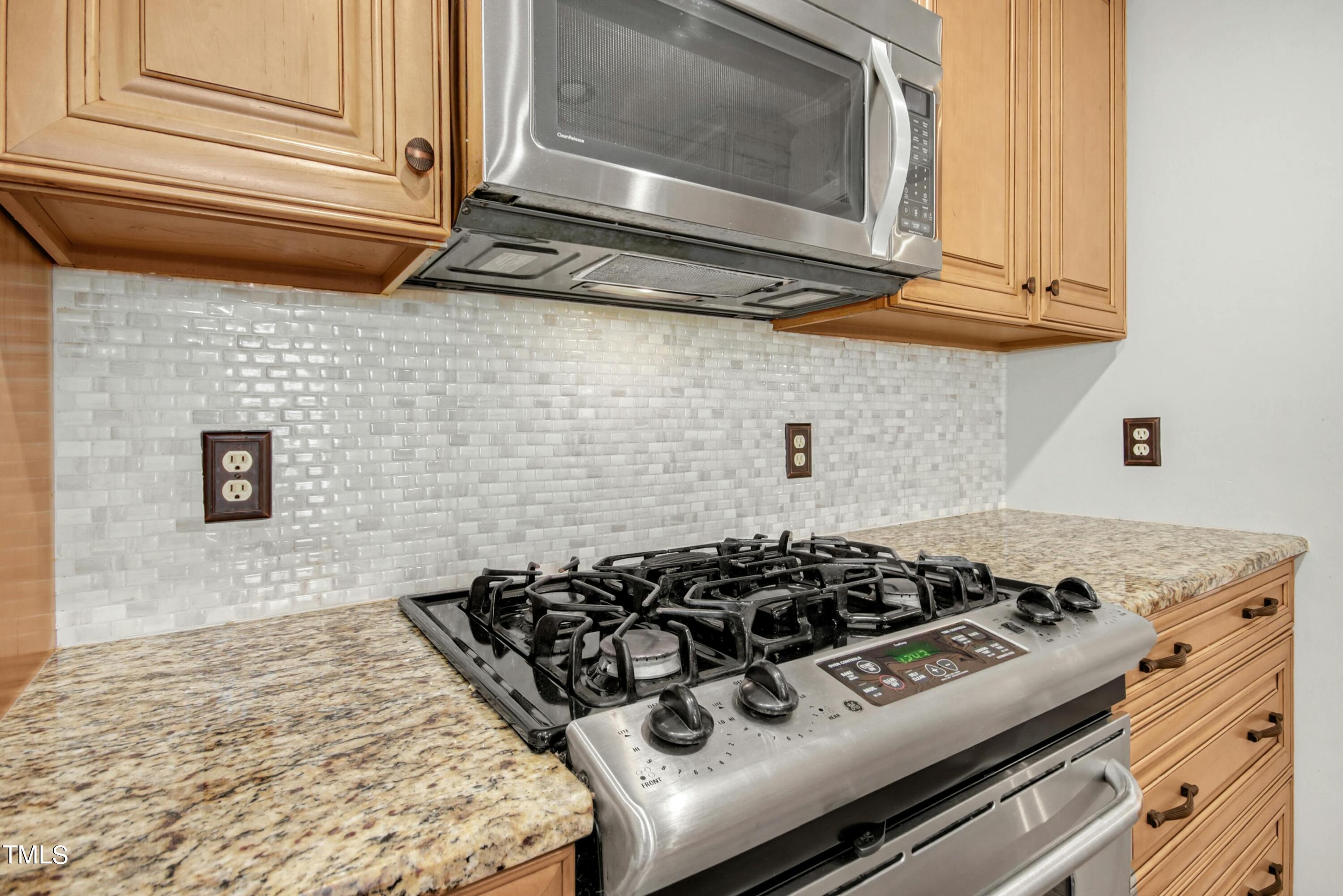 8605 Yucca Trail Raleigh, NC 27615 - Photo 14 of 42 a kitchen with a stove a microwave and cabinets